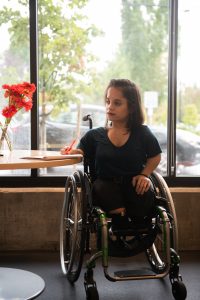 Woman in wheelchair writing at table